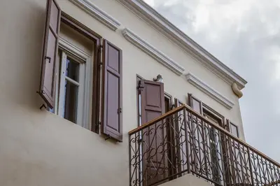 a balcony with brown shutters on a building at Zerania Suites in Rhodes Town