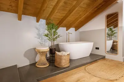 a bathroom with a bath tub and two plants at Zerania Suites in Rhodes Town