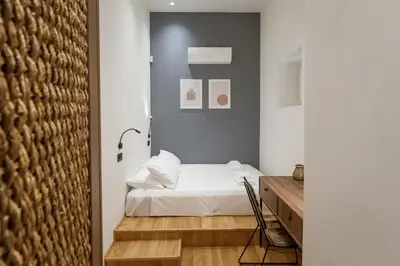 a bedroom with a white bed and a desk at Zerania Suites in Rhodes Town