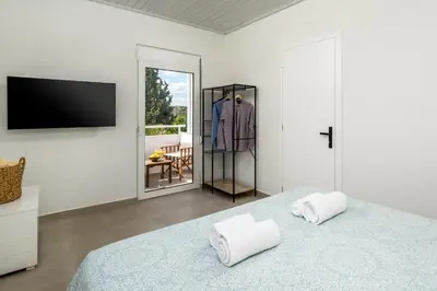 a bedroom with a bed and a tv and a mirror at Villa Costazia in Kalithies