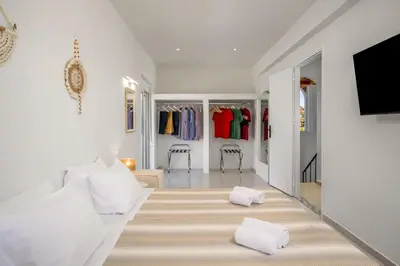 a living room with white furniture and a tv at Villa Costazia in Kalithies