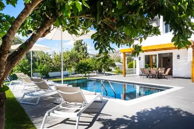 an image of a swimming pool with lounge chairs next to a house at Villa Costazia in Kalithies
