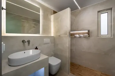 a bathroom with a sink and a toilet and a mirror at Villa Costazia in Kalithies