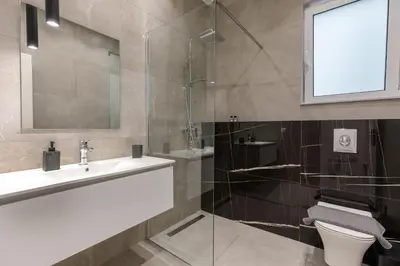 a bathroom with a sink and a toilet and a mirror at Micasa Suite Rhodos in Rhodes Town