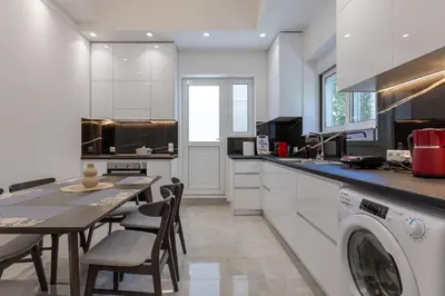 a kitchen with a table and a washing machine at Micasa Suite Rhodos in Rhodes Town