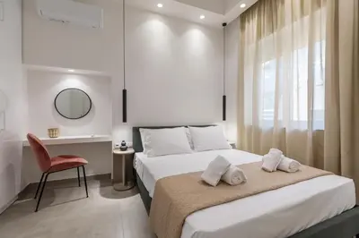 a bedroom with a bed and a desk and a chair at Micasa Suite Rhodos in Rhodes Town