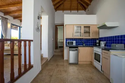 a kitchen with wooden cabinets and a stove top oven at Villa Pebble in Pefki Rhodes