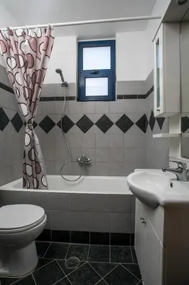 a bathroom with a tub and a toilet and a sink at Villa Pebble in Pefki Rhodes
