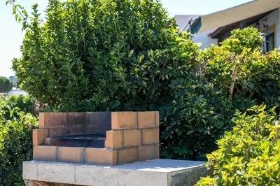 a stone fountain in front of a bush at Villa Pebble in Pefki Rhodes