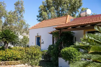 a white house with a red roof and a blue door at Villa Pebble in Pefki Rhodes