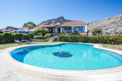 a swimming pool in front of a house at Villa Pebble in Pefki Rhodes