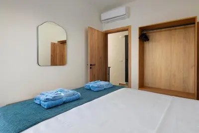 a bedroom with a bed with two blue towels on it at Elixir Vacation Houses in Gennadi
