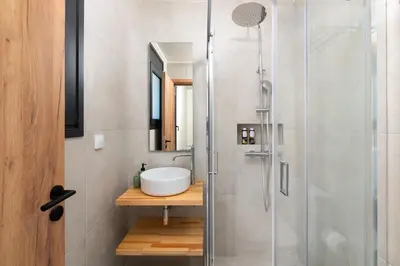 a bathroom with a sink and a shower at Elixir Vacation Houses in Gennadi