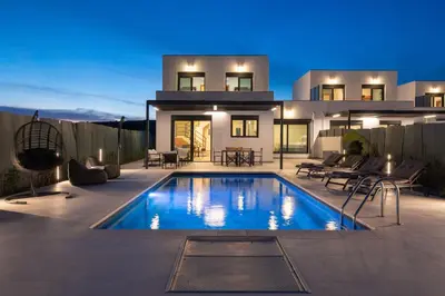 a house with a swimming pool in front of a house at Elixir Vacation Houses in Gennadi