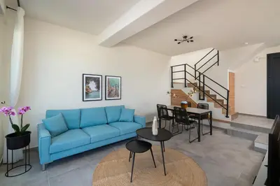 a living room with a blue couch and a table at Elixir Vacation Houses in Gennadi