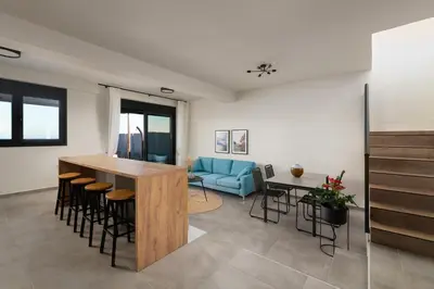 a living room with a blue couch and a table at Elixir Vacation Houses in Gennadi
