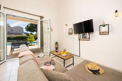 a living room with a couch and a flat screen tv at Villa Athena Classico in Kolimbia