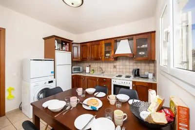 a kitchen with a wooden table and a dining room at Villa Athena Classico in Kolimbia