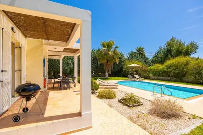a backyard with a swimming pool and a grill next to a house at Villa Apollo Classico in Kolimbia