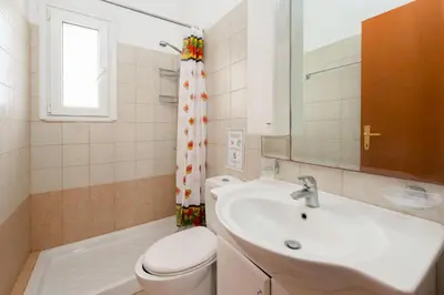 a bathroom with a sink and a toilet and a mirror at Villa Apollo Classico in Kolimbia