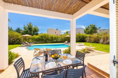 a patio with a table and chairs and a pool at Villa Apollo Classico in Kolimbia