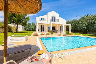 a villa with a swimming pool in front of a house at Villa Apollo Classico in Kolimbia