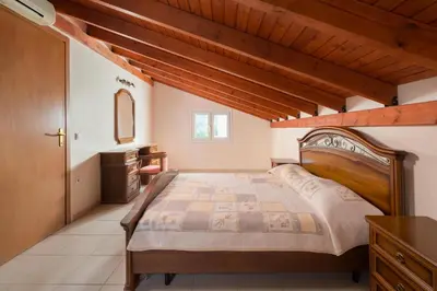 a bedroom with a large bed and a sink at Villa Apollo Classico in Kolimbia