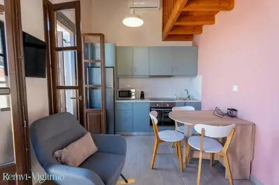 a kitchen and dining room with a table and chairs at Remvi Seaside Houses in Halki