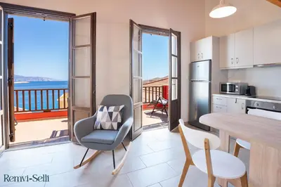 a kitchen and dining room with a table and chairs at Remvi Seaside Houses in Halki