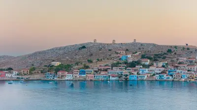 a group of houses on a hill in the water at Remvi Seaside Houses in Halki
