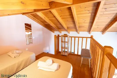 two beds in a room with wooden ceilings at Remvi Seaside Houses in Halki