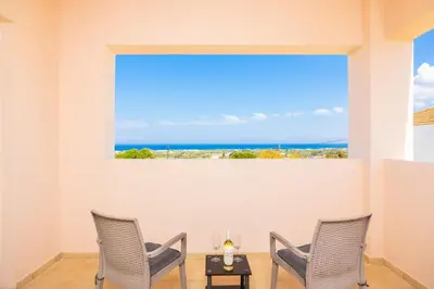 two chairs and a table in a room with a large window at Villa Maia in Phanaes