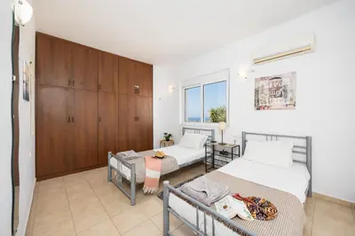 a bedroom with two beds and a wooden cabinet at Villa Maia in Phanaes