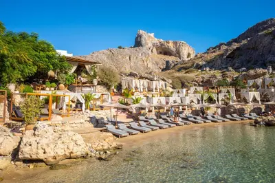 a beach with chaise lounges and chairs at Villa Maia in Phanaes