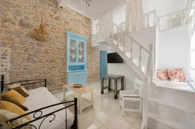 a living room with a staircase in a brick wall at Castello Venetsiana in Symi