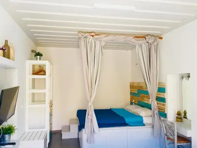 a bedroom with a bed with a curtain at Annika Deluxe Apartments in Symi
