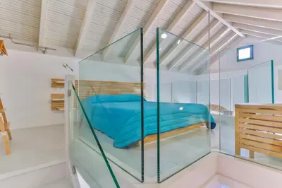 a glass house with a blue bed in it at Annika Deluxe Apartments in Symi