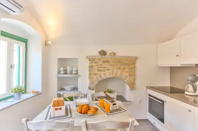a kitchen with a table with bread and orange juice at Annika Deluxe Apartments in Symi