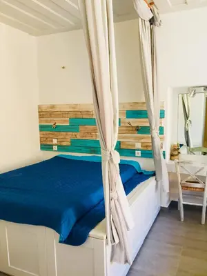 a bedroom with a bed with a wooden headboard at Annika Deluxe Apartments in Symi
