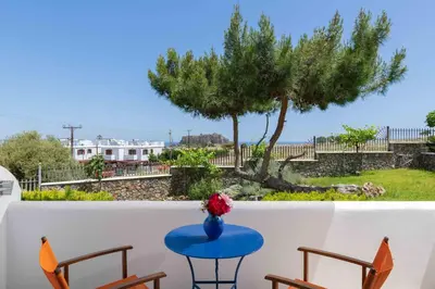a blue table on a balcony with a tree at 'Lindian Myth' Sea View Studios in Líndos