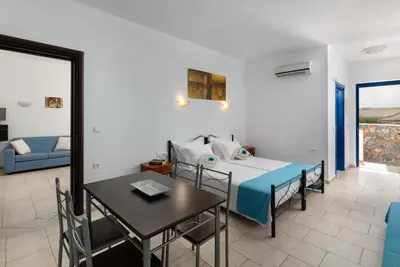 a bedroom with a bed and a table and a dining room at 'Lindian Myth' Sea View Studios in Líndos