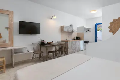 a bedroom with a bed and a kitchen with a table at 'Lindian Myth' Sea View Studios in Líndos