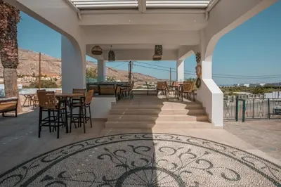 a patio with tables and chairs and a view of the mountains at 'Lindian Myth' Sea View Studios in Líndos