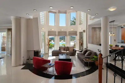a large living room with red chairs and a couch at Andrealexia Sea View Villa in Kalithies