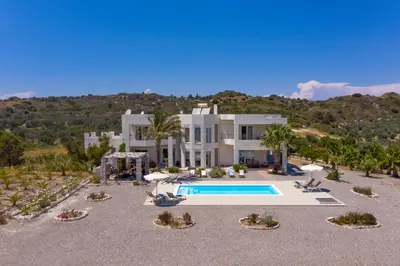 a large white house with a swimming pool at Andrealexia Sea View Villa in Kalithies
