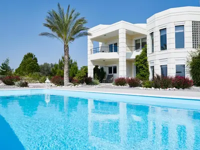a villa with a swimming pool in front of a house at Andrealexia Sea View Villa in Kalithies