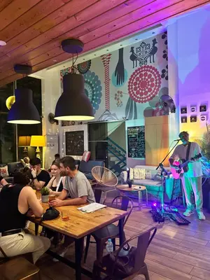 a group of people sitting at tables in a restaurant at STAY Rhodes HoStel & Bar in Rhodes Town