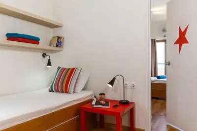 a small bedroom with a bed and a red table at STAY Rhodes HoStel & Bar in Rhodes Town