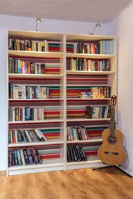 a book shelf filled with books and a guitar at STAY Rhodes HoStel & Bar in Rhodes Town