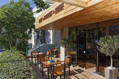 an outdoor patio with wooden tables and chairs at STAY Rhodes HoStel & Bar in Rhodes Town